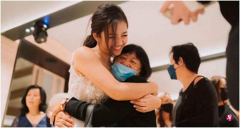 蔡文光（中）拥抱丽达，感谢她特意飞来参加她的婚礼。（取自《联合早报》，受访者提供）