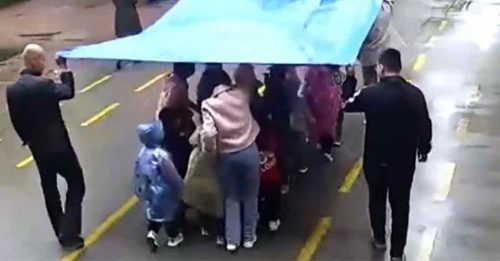 爱心老师手撑遮雨布 护送314名幼童放学