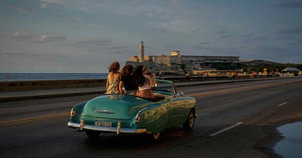 游客乘坐一辆老式美国汽车，沿着哈瓦那马勒孔大道兜风。（美联社）
