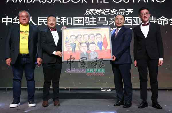 李祥福（左2起）代表大专青，赠送纪念品给欧阳玉靖；左起为张庆信和叶志华。
