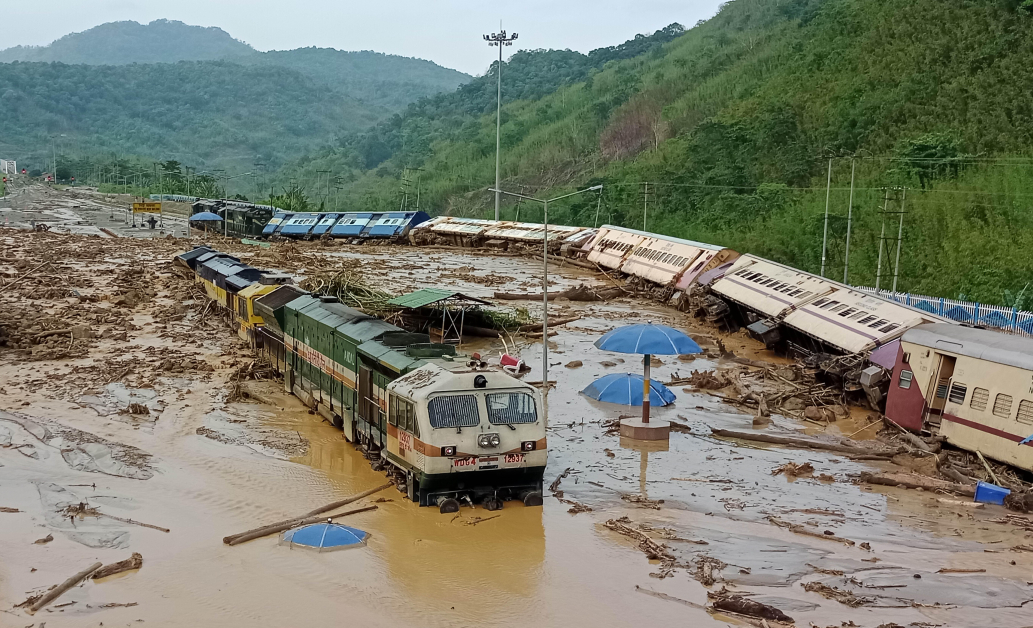 豪雨引发广泛洪水，印度东北部阿萨姆州的新哈夫隆火车站的火车，16日被土石流冲到翻覆。（美联社）