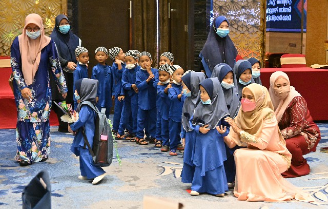 约20名来自希望孤儿院孩童，排队等待领取恩物。