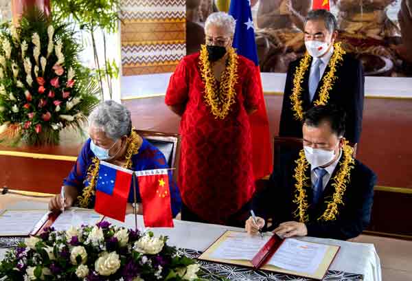 萨摩亚外交部长西米（左）与中国大使巢小良（右）在萨国总理菲娅梅（后左）和中国外长王毅见证下，周六签署扩大经贸等方面合作协议。（法新社）