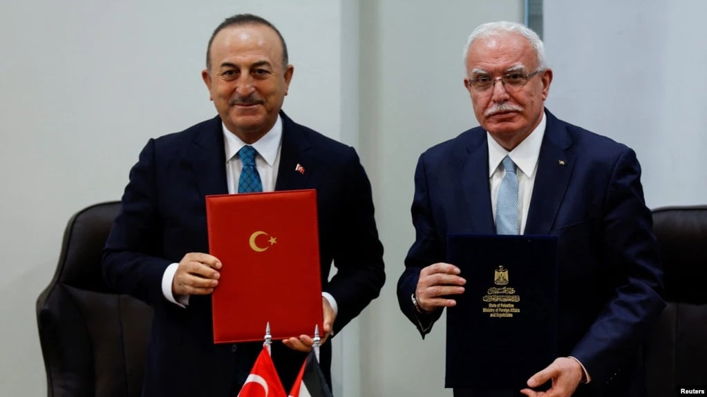 土耳其外长恰武什奥卢（左）24日在约旦河西岸城市拉姆安拉与巴勒斯坦外长马立基会面并签署协议。