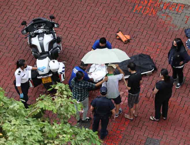 死者家属撑伞到事故现场认遗体。