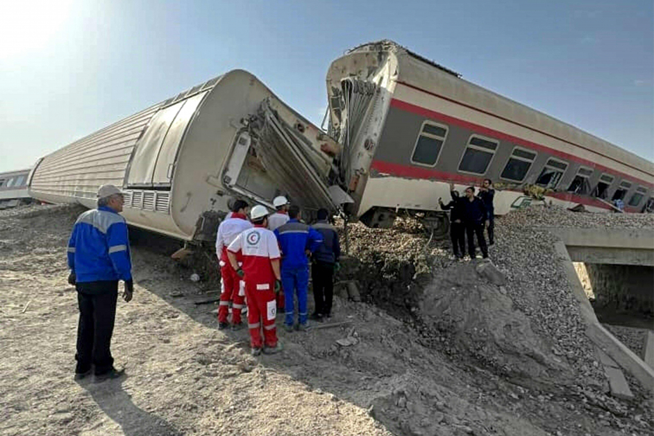 火车脱轨翻覆，搜救人员在现场救援。（法新社）