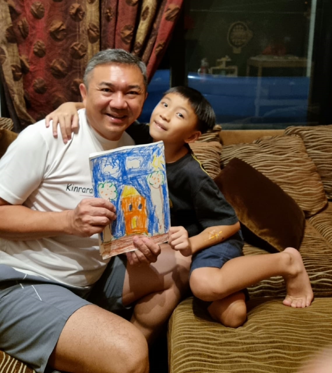 黄思汉（左起）在今年的父亲节收到长子亲手制作的双亲节卡片，两人开心合影。