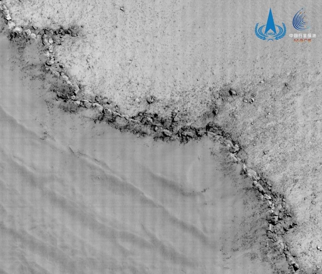 环绕器高分相机拍摄蒙德环形坑边缘影像，空间分辨率约0.5公尺，该环形坑直径约91公里，图像展示了蒙德环形坑坑缘的地貌特征，图左下部为环形坑内部，坑缘可见明显向坑内坍塌的现象。