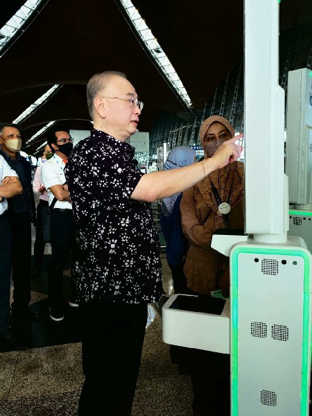 机场工作人员替魏家祥拍摄一段关于大马机场最新的生物识别登机程序的视频。