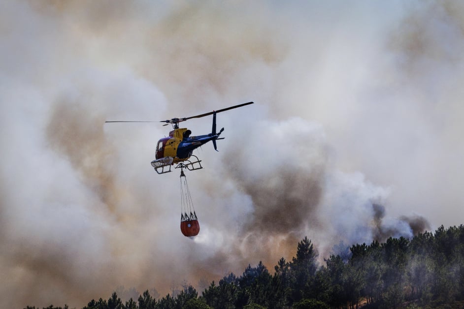 周二在葡萄牙瓦尔帕科斯（Valpacos）的卡巴纳斯（Cabanas），一架直升机对着森林洒水灭林火。（欧新社）