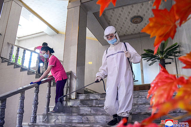 朝鲜卫生人员在平壤一家酒店进行消毒作业。（法新社）