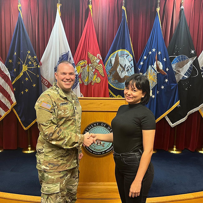 莎拉和一名美国军人握手合照。
