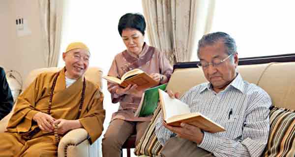 净空法师（左）某次访马时，趁机与马哈迪（右）交流，后者在会面上阅读《群书治要》的英译本。（取自www.xuefo.net）
