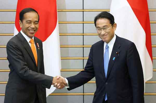 日本首相岸田文雄（右），周三在首相办公室会见印尼总统佐科威，两人亲切握手寒暄。（法新社）
