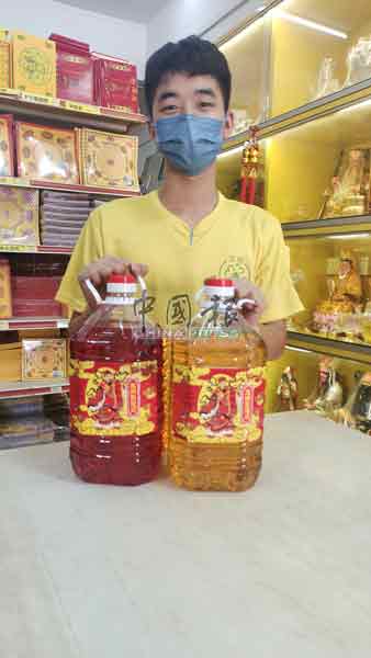 黄钲贤展示每5公斤瓶装，售价36令吉的拜神油。