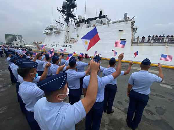 菲律宾海岸警卫队队员周二在马尼拉港口，挥舞小旗子，列队欢迎美国巡逻舰“米吉特号”。（欧新社） 