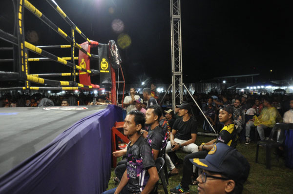 泰拳比赛露天举行，观众冒雨观赛。