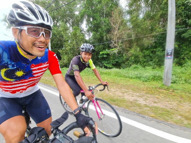 锺颖光（左）和嘉楼州级公路骑手艾曼一起骑行。