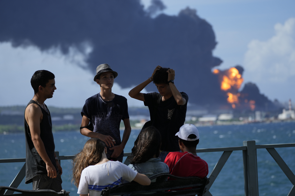 马坦萨斯青少年周六聚集在码头，不因燃料储存库爆炸起火而担心。（美联社）