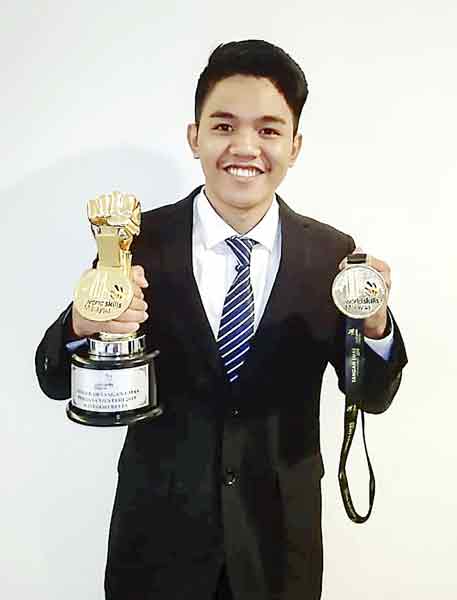 祖文苏依展示他在2019年获得的“金手奖”奖杯和奖牌。