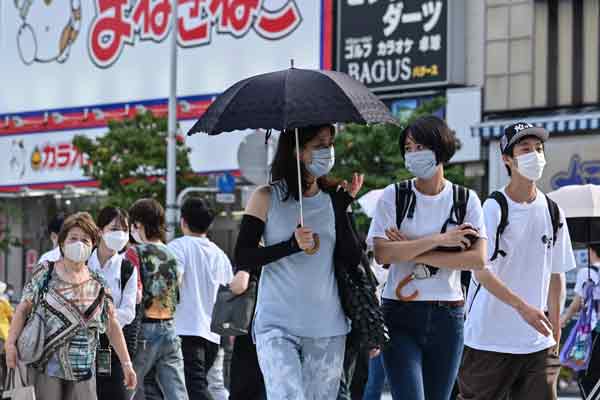 东京新宿街头，行人戴口罩防疫。