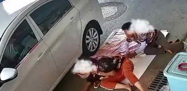 中国两个大妈跑去睡马路，一辆小客车不察，转弯时前轮辗过两个大妈。