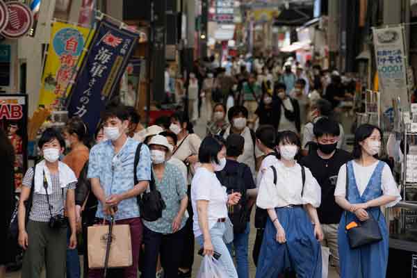 日本民众7月28日戴口罩经过东京银座街头。（美联社）
