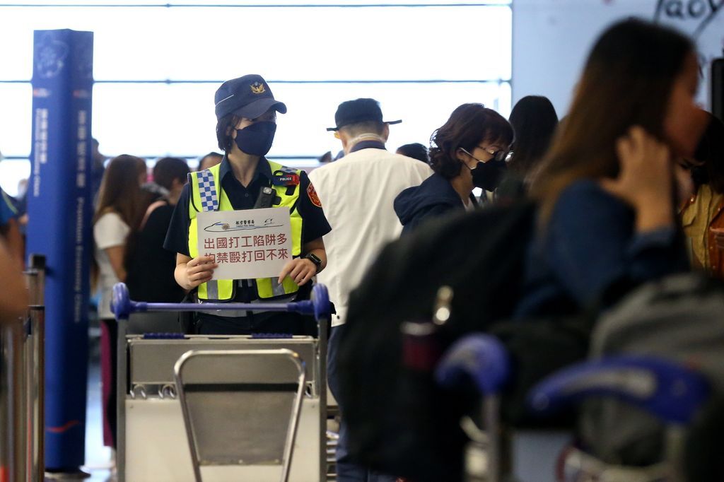 台湾桃园机场航警举牌提醒民众。