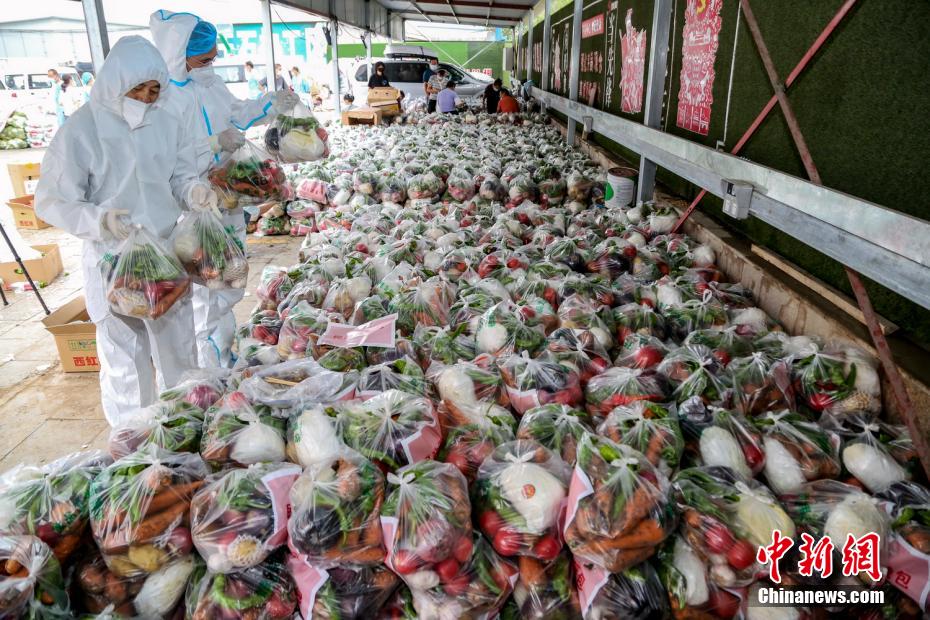 新疆乌鲁木齐市沙依巴克区水利社区的志愿者，准备将“蔬菜包”送往困难群众手中。（中新网）