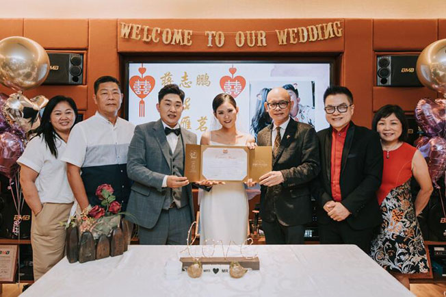 蒋志鹏（左3起）和庄雁茗在证婚人卓顺发（右3）和张仰兴（右2）的祝福下，在TeoHeng门市店注册结婚。（受访者提供）