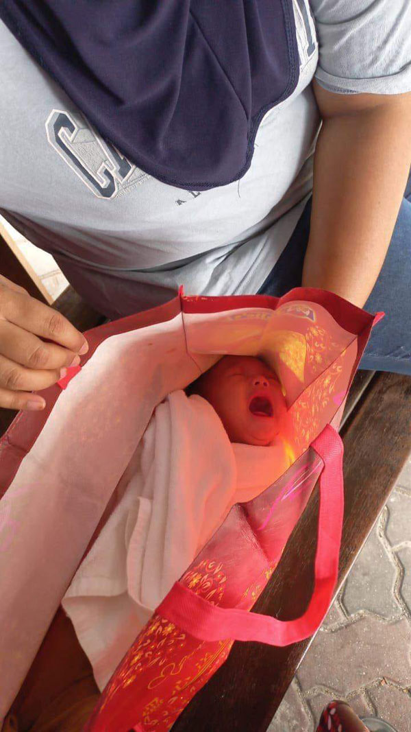 可爱的婴儿被人装在红色环保袋内抛弃。