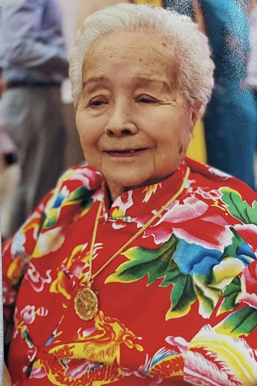 百岁宴时，老妇身穿喜庆新衣。