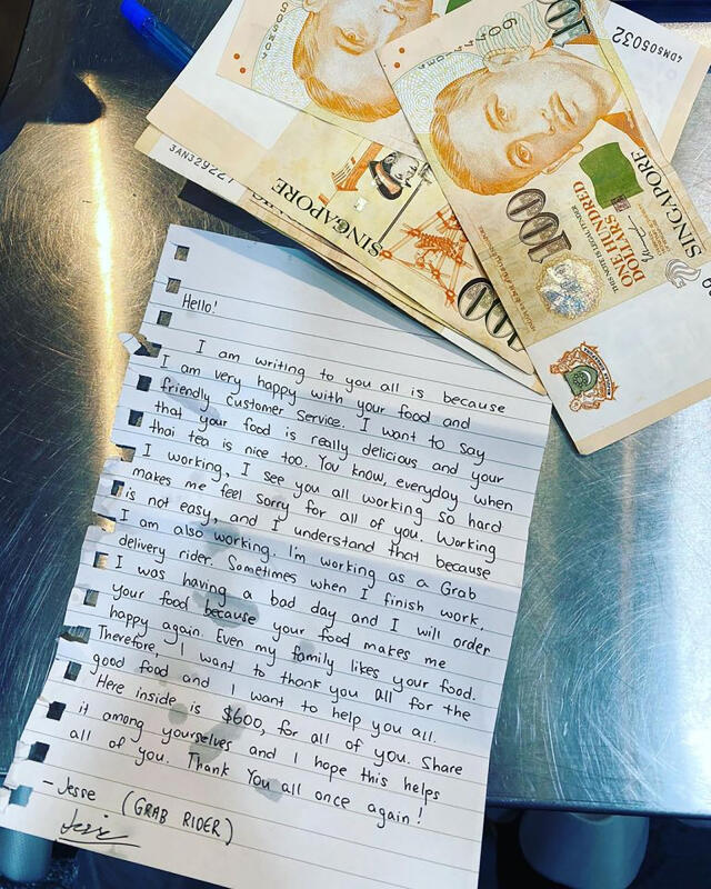 送餐員傑西給600新元現金，感謝泰國餐館的職員。（受訪者提供）