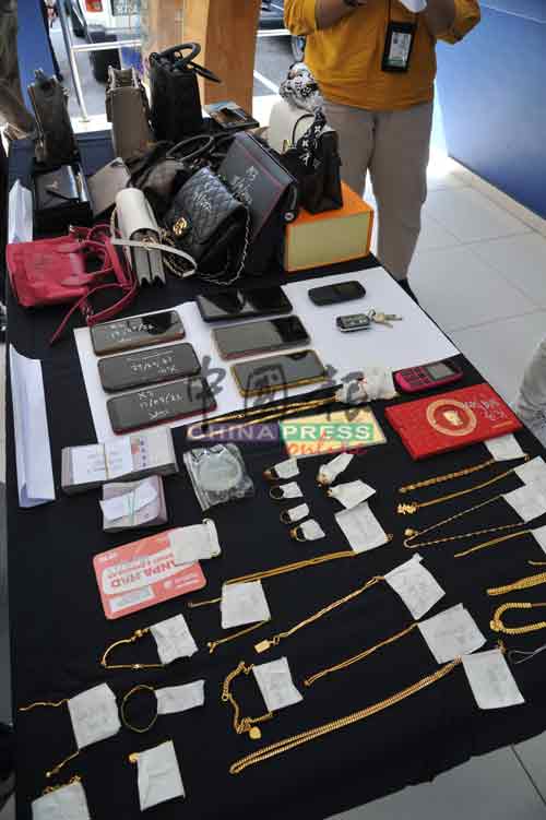 警方展示所起获的各类首饰、手机、名牌手提袋，以及大量现金等证物。