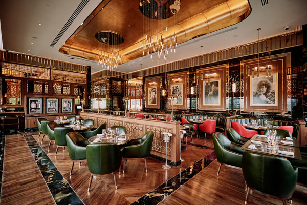 餐厅的装潢以大红色配上森林绿家具，装饰在沉稳抛光的核桃木地板上，再缀以手工填饰的24K金天花，带出英伦风的古典与高雅。