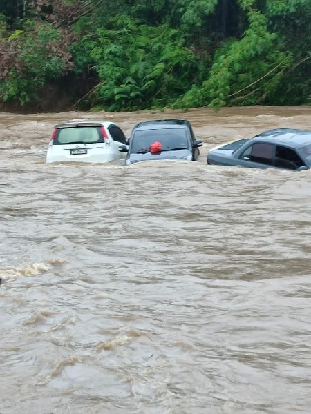 山洪爆发时，车子在湍急的水流中载沉载浮。