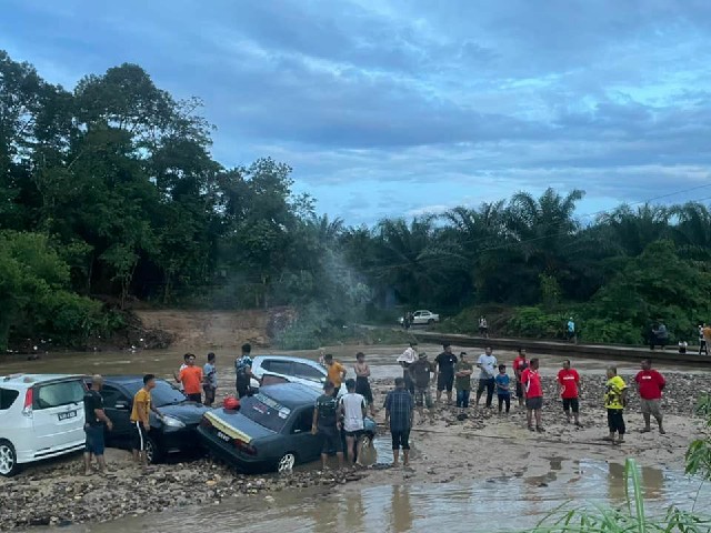 居民协助幸存者拖出陷在泥里的车子。