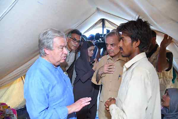 巴基斯坦总理谢里夫（中）和古特雷斯（左），周六在俾路支省慰问受灾群众。（法新社）