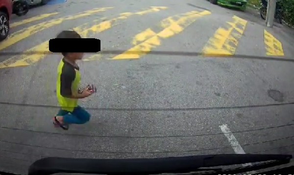 身穿黄衣的儿子，从一辆轿车的后方冲出马路。