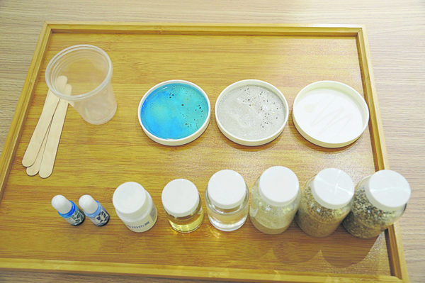 材料：树脂（透明色）、圆盘、搅拌棒、细沙、硬化剂（黄色）、白色色膏（做海浪）、深蓝和浅蓝色素（海洋色泽）。