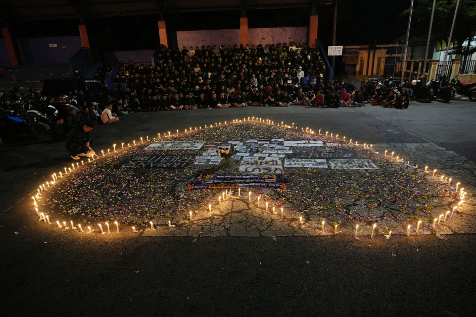 球迷周一晚在甘朱鲁汉体育场外，用烛光围成心形，悼念踩踏事件死难者。（美联社）