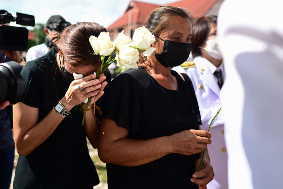 在农磨兰普府的托儿所，死者家属准备出席哀悼仪式，献上白玫瑰。（法新社）