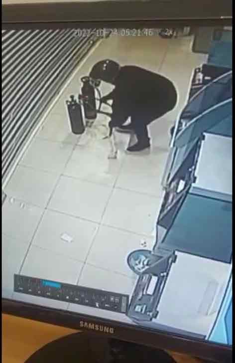 闭路电视画面显示1名男子进入银行并使用氧气筒焊烧自动提款机。
