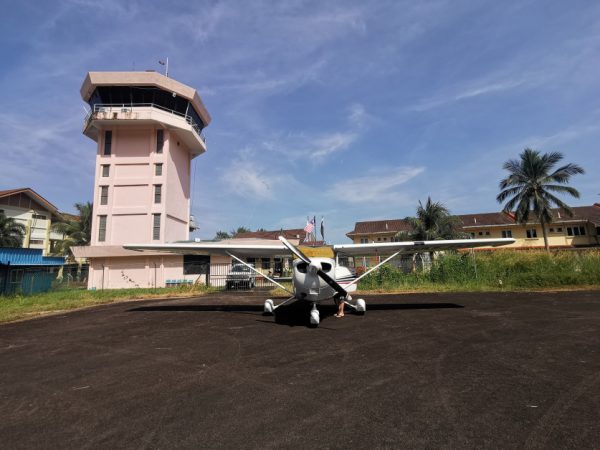 罗英铭飞过森林海洋上空，驾着小飞机来到刁曼岛，停在岛上机场停机坪，后为刁曼岛空管台。