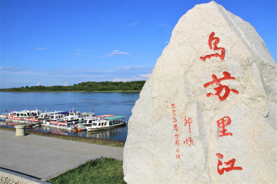 中国在乌苏里江岸边安置一座纪念碑供打卡，江面上是游江的游艇。