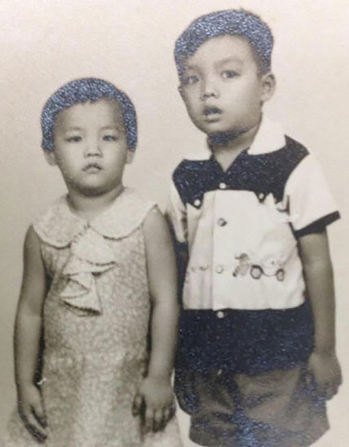 廖文财（右）与妹妹廖秀蓉（左）儿时的照片。（受访者提供）