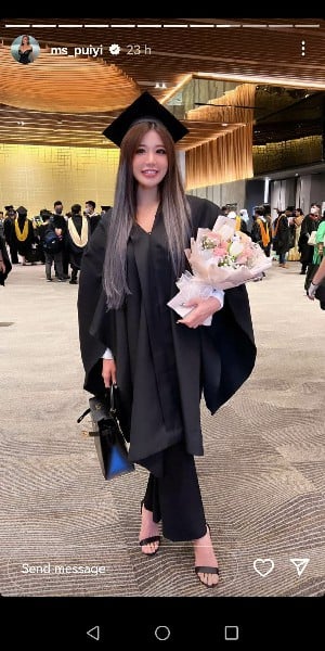 身穿毕业袍的Ms Puiyi拿着花束，难掩心中喜悦。