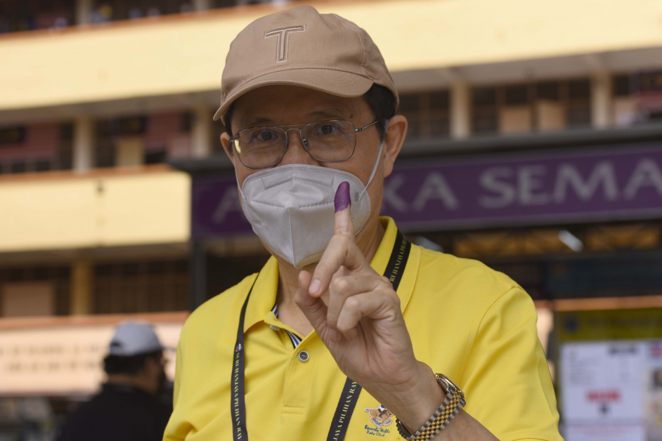 翁诗杰展示沾了墨汁的手指，证明自己已经投票。