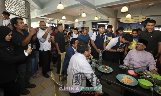 几名学生排队轮流与安华问好，并顺道与新科首相合影留念。