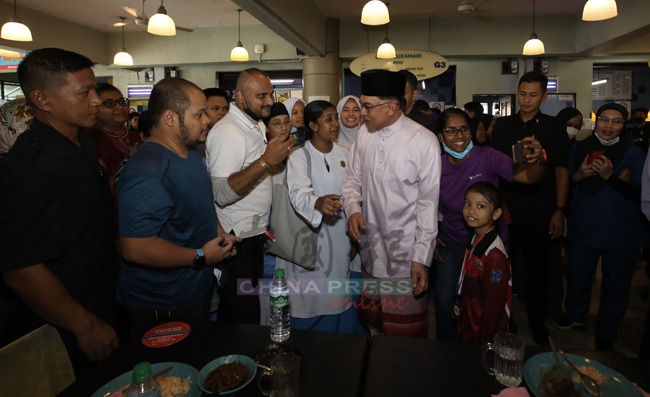 安华在用餐前，与几名民众交流一番。